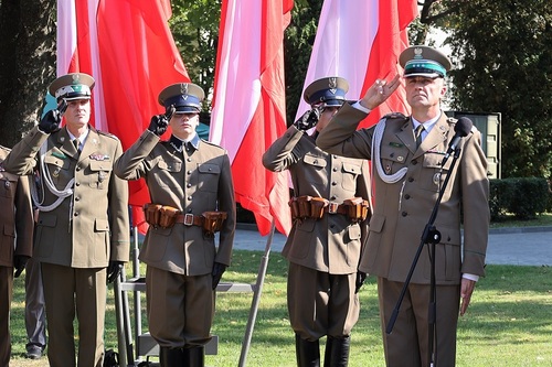 Rektor – Komendant WSSG, funkcjonariusze w historycznych mundurach oraz dowódca uroczystości podczas odgrywania hymnu państwowego. 