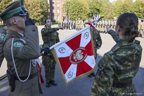 Delegacja studentów ustawia się po obu stronach pocztu podczas ślubowania.