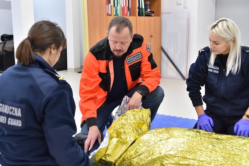 Dwie funkcjonariuszki wraz z ratownikiem medycznym w trakcie ćwiczeń praktycznych Dwie funkcjonariuszki wraz z ratownikiem medycznym w trakcie ćwiczeń praktycznych